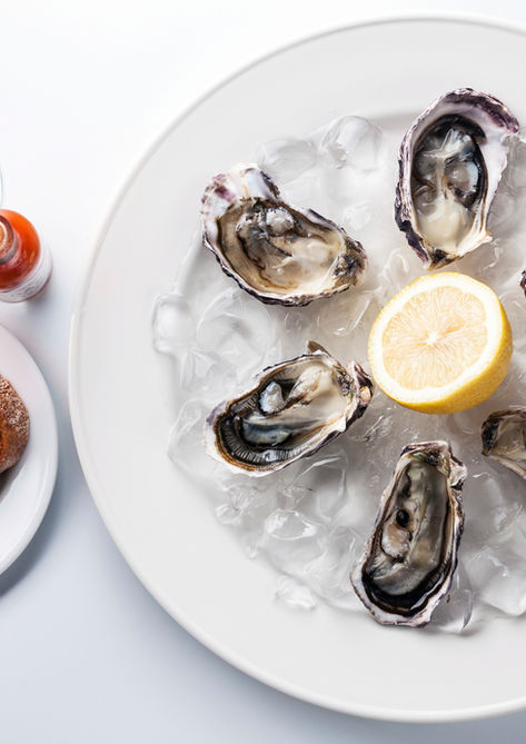 Oysters on ice with lemon, bread, butter, and rosé wine.