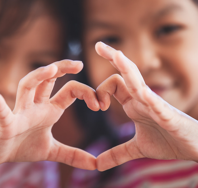 Siblings holding the heart sign with hands