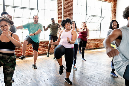 Group of people in an energetic dance exercise class representing the vitality and joy of moving through the second half of life with hormone optimization.