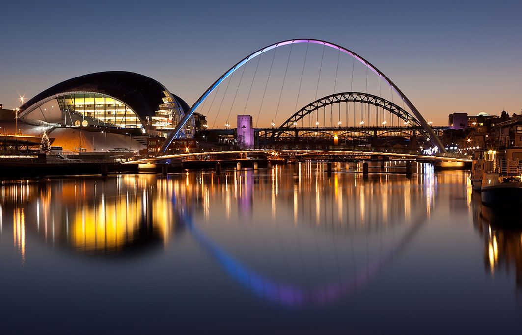 Newcastle and Gateshead at sundown showing Gateshead Millennium Bridge and Tyne Bridges
