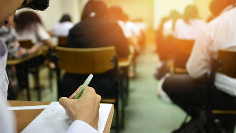 a view from the back row of a college classroom full of students at their desks