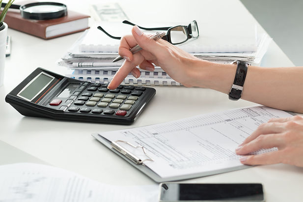 Close-up of female accountant's hand while using calculator