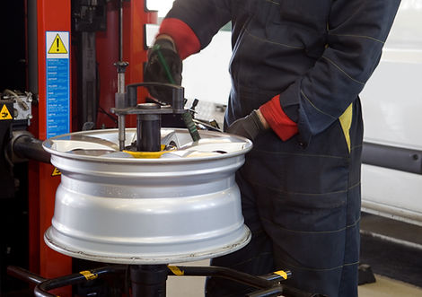 View of a mechanic inspecting the wheel of a car