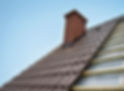 Roof under construction with lots of tiles and red brick chimney