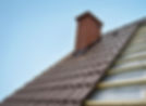 Roof under constructions with lots of tile and red brick chimney