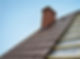 Roof under constructions with lots of tile and red brick chimney