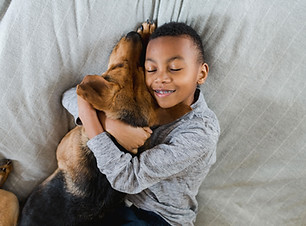 Child hugging pet dog