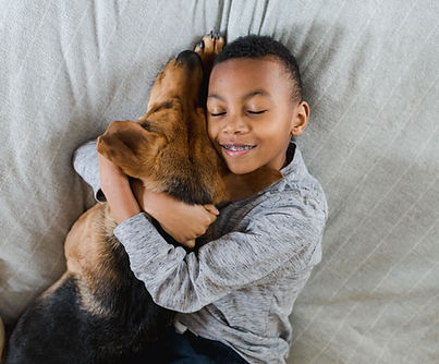 Child hugging pet dog