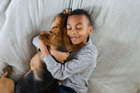 Child hugging pet dog