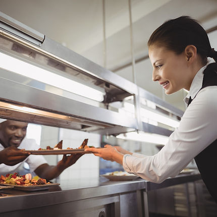 Chef handing food to server