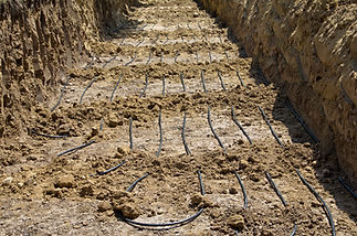 A trench filled with plastic tubing used for the installation of a geothermal residential