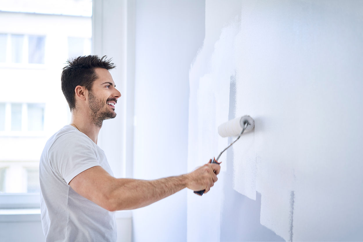 Man painting wall in apartment