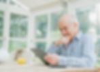 man in conservatory looking at tablet