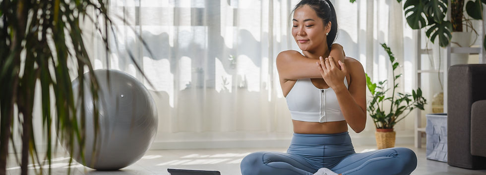 Smiling Asian woman watching yoga instruction using a tablet