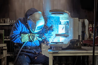 Welder creating sparks indoors