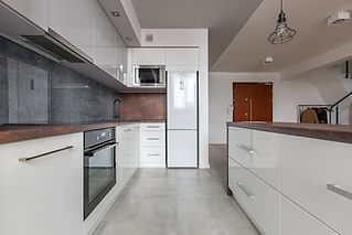 Modern apartment kitchen with functional granite worktop and island with sleek cabinetry