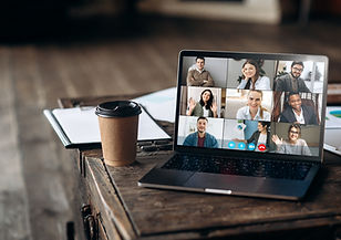 Laptop auf Schreibtisch mit Kaffee und Unterlagen zeigt Online-Gruppenkurs Englisch per Videokonferenz in München
