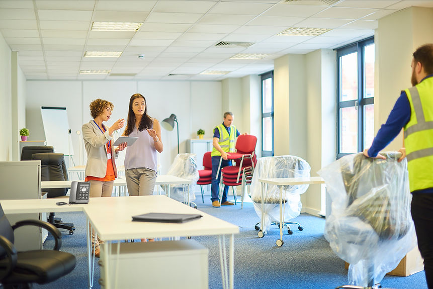 Two women discuss plans with a tablet in an office space