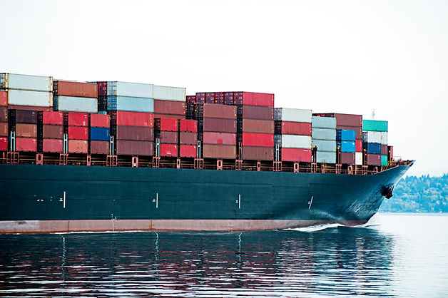 High-angle view of a cargo ship stacked with shipping containers cruising at sea