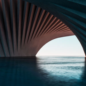Curved architectural structure over calm water, with blue and pink lighting. Open sky visible in the background, creating a serene mood.