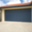 A blue double garage door on a brand new home