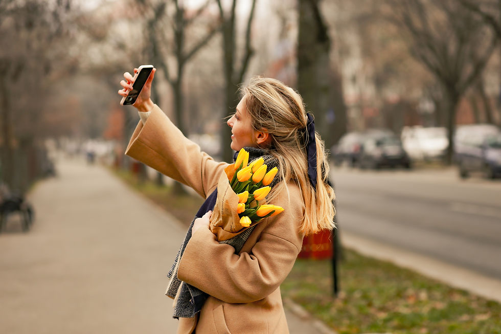 Lady holding flowers and taking a selfie