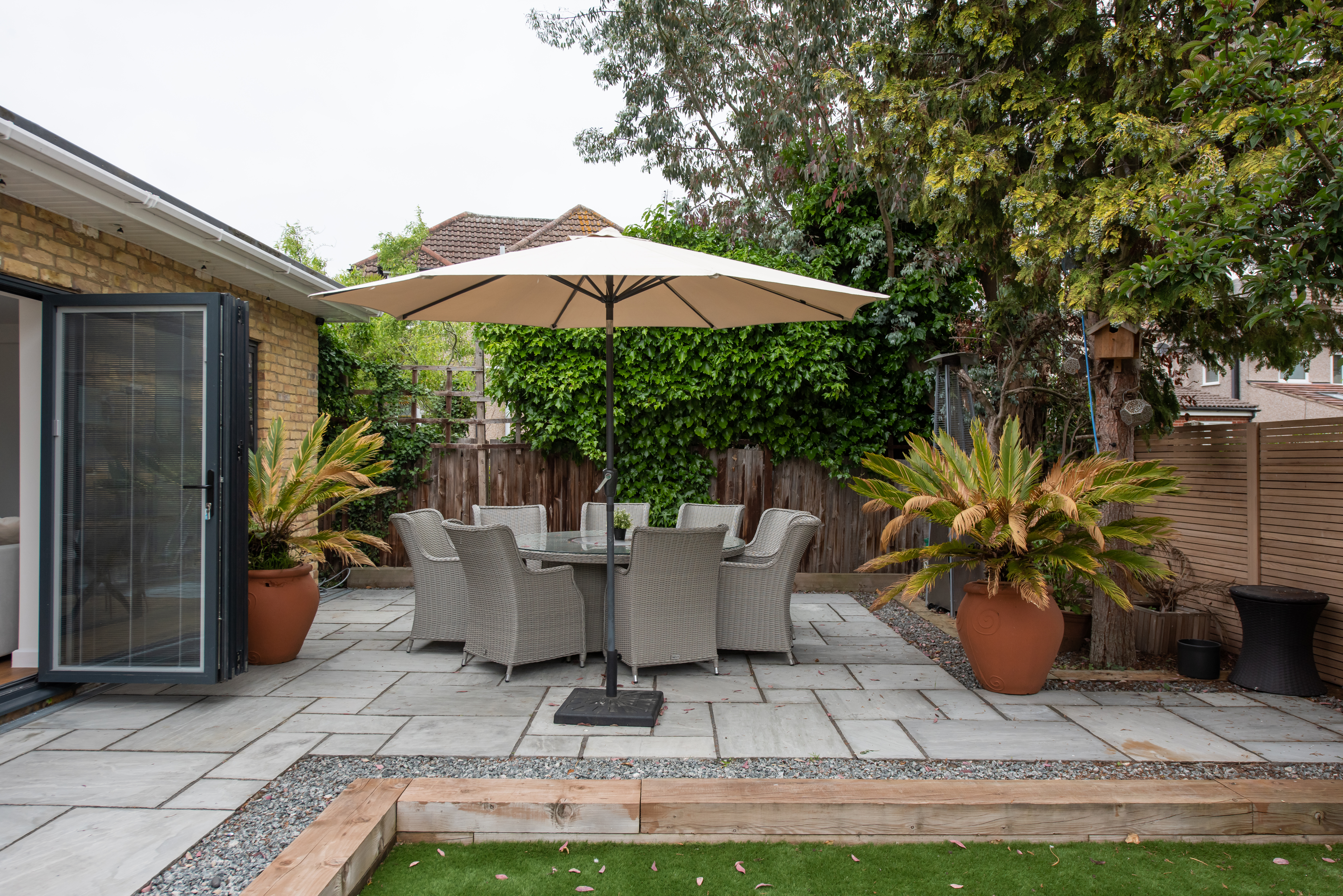 A general exterior view of a round garden furniture table and chairs on a patio