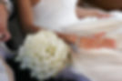 bride and groom sit in limo with bouquet