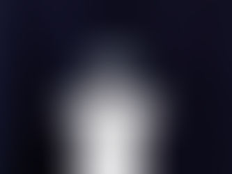 Goldfish in a round bowl on a white pedestal against a dark blue curtain. The scene is serene with vibrant orange and deep blue contrasts.