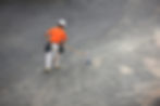 A construction worker sweeps a grey surface with a broom