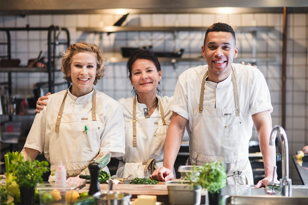 Three chefs smiling in a kitchen