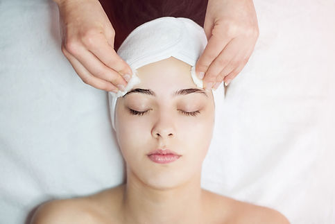 Woman receiving facial massage in beauty salon