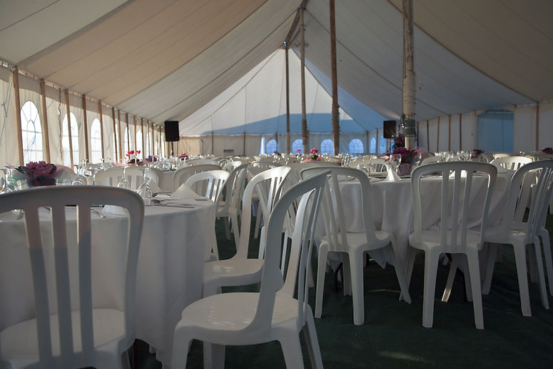 Function room venue set with rows of white chairs for event guests