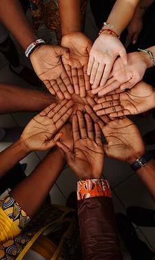 Group of hands together symbolizing community support and teamwork for newcomer families