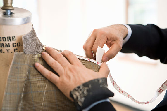 Tailor measures and chalks jacket shoulder