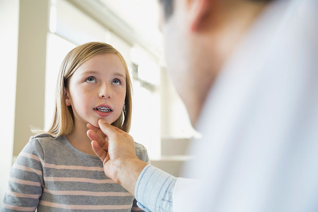 Dentist looking at young girl's teeth