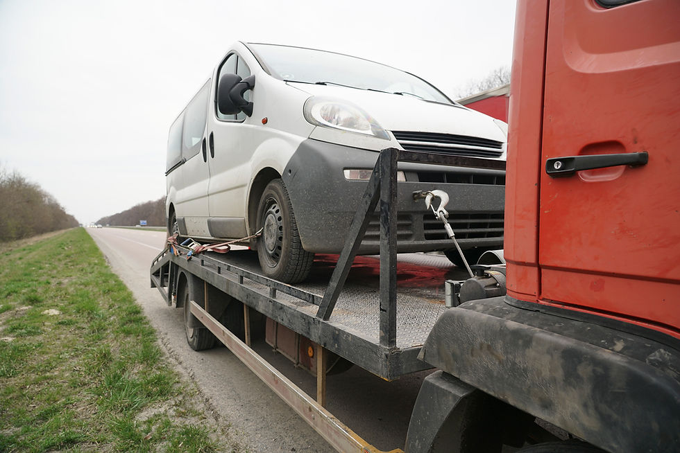 Loading a white van on to a tow truck.
