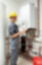 Engineer in a hard hat inspecting home boiler pipework