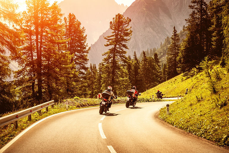 Group of motorcyclists riding on curves mountainous road, race of motorbike in Alps, beaut