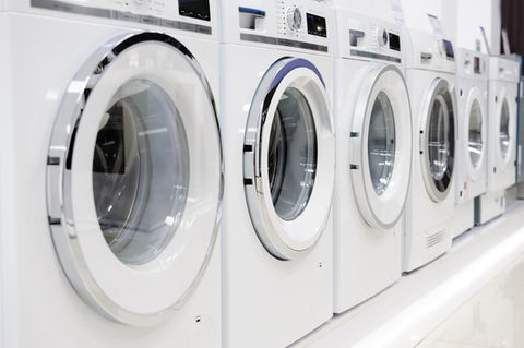 Row of modern, white front-loading washing machines in a store