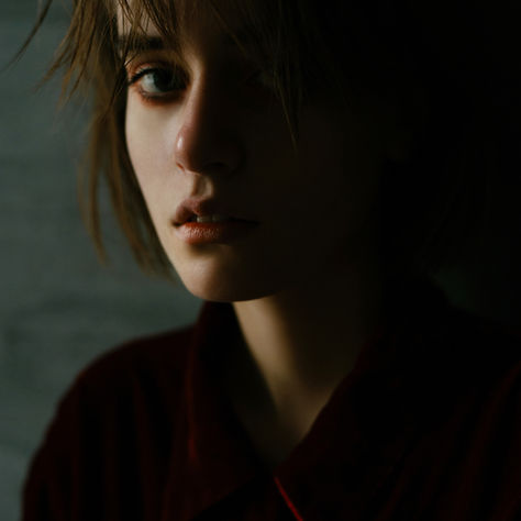Teen sitting alone in a bedroom looking thoughtful, representing emotional ups and downs during adolescence