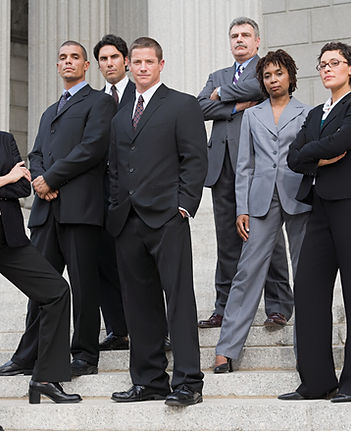  Group of corporate professionals in business attire posing confidently on outdoor stone steps.