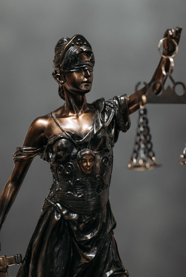 A bronze statue of Lady Justice, depicted with a blindfold and scales, symbolizes fairness and impartiality in the legal system.