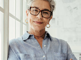 Menopause health content featuring an older woman looking into the camera and smiling