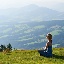 Woman meditating on alpine meadow
