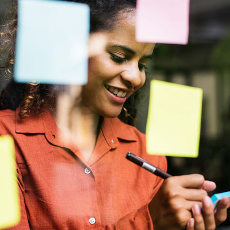 woman writing on sticky notes