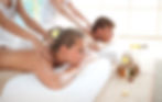Young couple in SPA enjoying back massage by two massage therapists