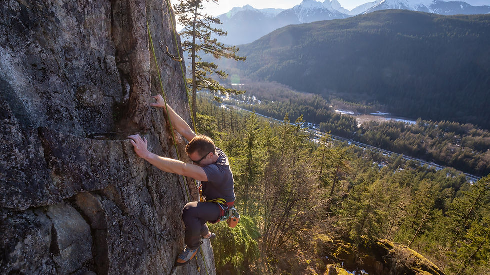 Man rock climbing with a scenic view behind