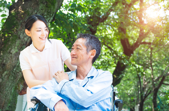 Elderly Patient In Wheelchair And Caregiver