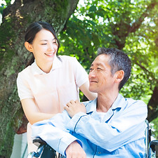 Elderly Patient In Wheelchair And Caregiver
